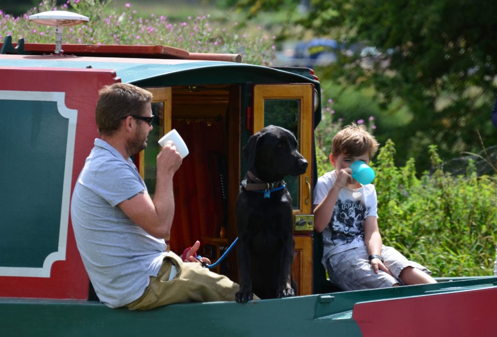 Father, son and dog in the bow of narrowboat