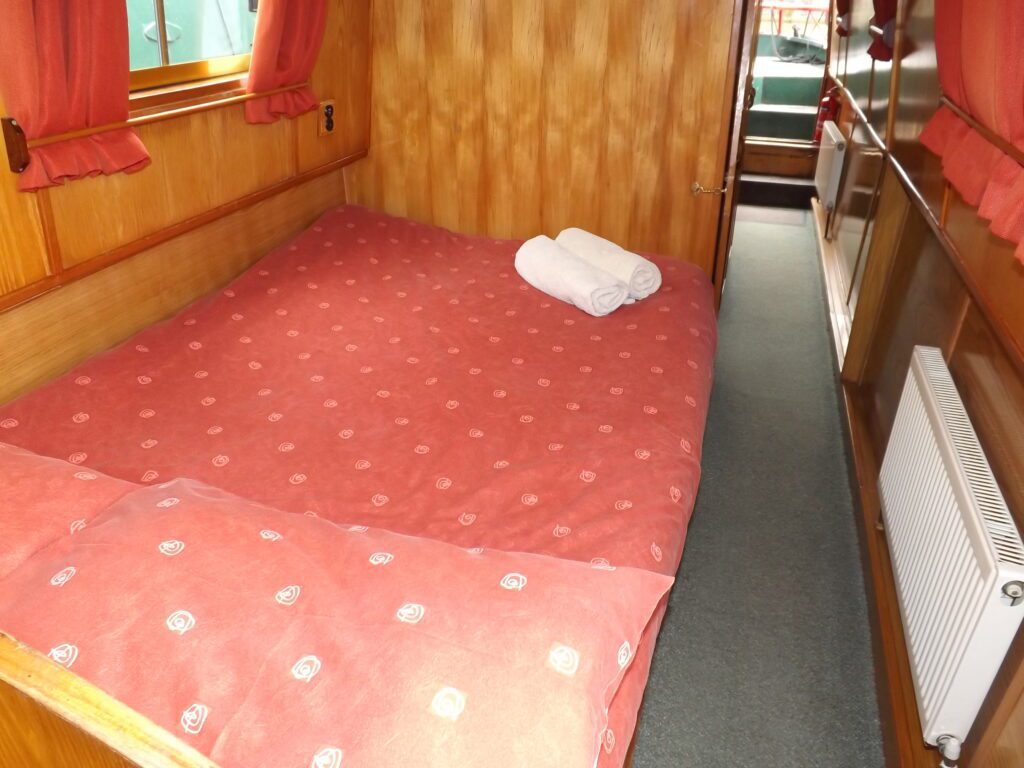 The forward middle cabin on narrowboat Foxhunter with a comfortable fixed double bed and plentiful storage.